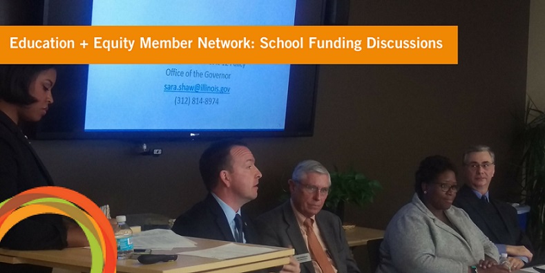 panelists at education equity discussion sitting at a table with a screen behind them. 